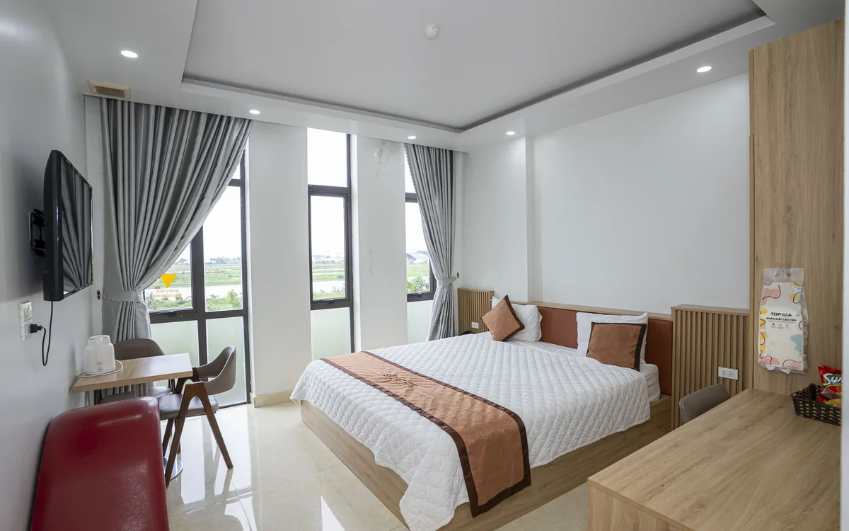 Homestay An Lão – phòng giường đôi có dãy cửa sổ kính nhìn ra cánh đồng tại Sao Việt Hotel