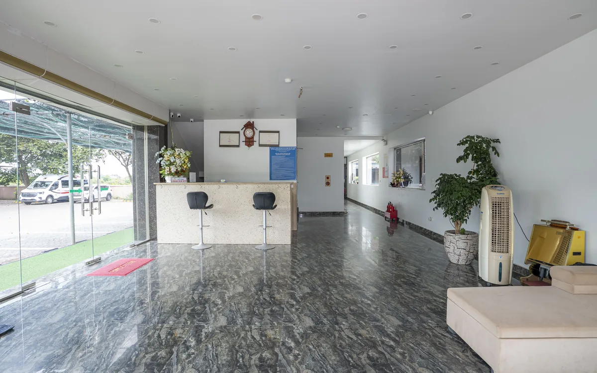 Homestay An Lão – sảnh và quầy lễ tân sàn đá, cửa kính lớn tại Sao Việt Hotel