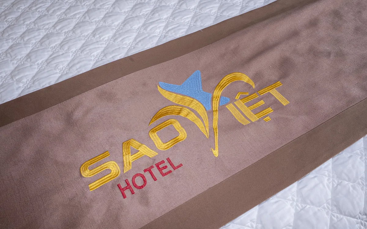 Khuyến mãi khách sạn An Lão – khăn trang trí trên giường thêu logo Sao Việt Hotel màu vàng xanh