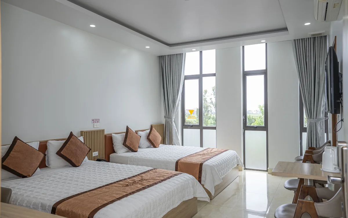 Khuyến mãi khách sạn An Lão – phòng 2 giường ga trắng, bàn ghế gỗ, TV treo tường và cửa sổ kính lớn tại Sao Việt Hotel