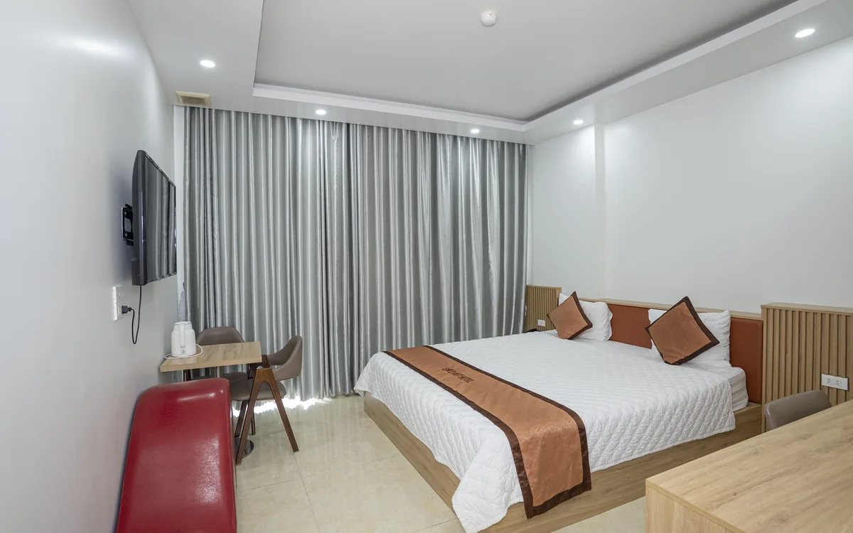 Minibar khách sạn – phòng 1 giường đôi sàn gạch sáng, TV treo tường, rèm xám tại Sao Việt Hotel An Lão
