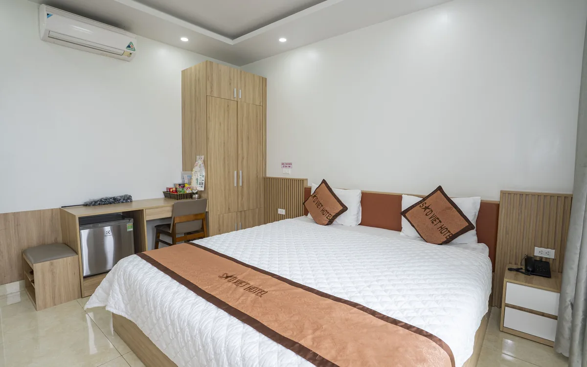 Minibar là gì – phòng giường đôi có tủ gỗ, bàn và tủ lạnh nhỏ dưới bàn, điều hoà tại Sao Việt Hotel