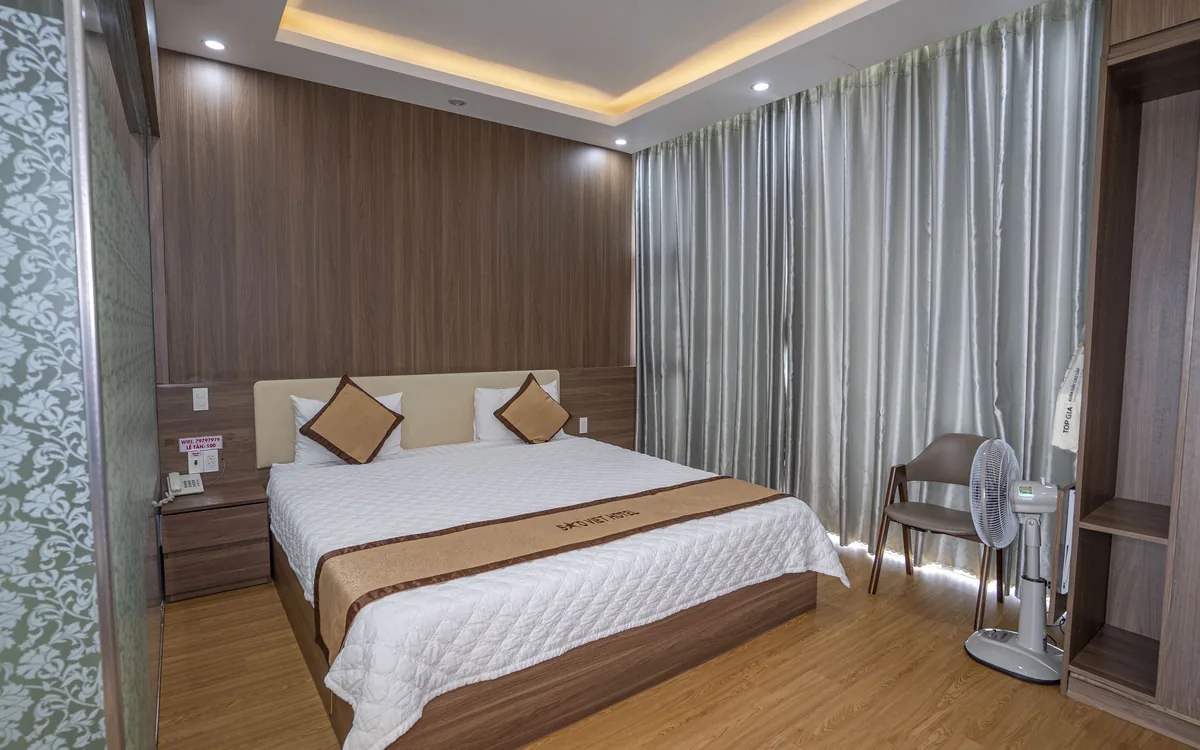 Phòng có cửa kính lớn ra ban công, giường đôi và quạt cây tại Sao Việt Hotel