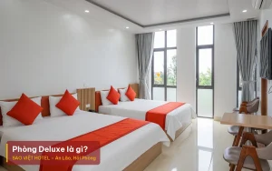 Phòng Deluxe là gì – ảnh minh hoạ phòng khách sạn có hai giường đôi, kèm tiêu đề bài viết của Sao Việt Hotel