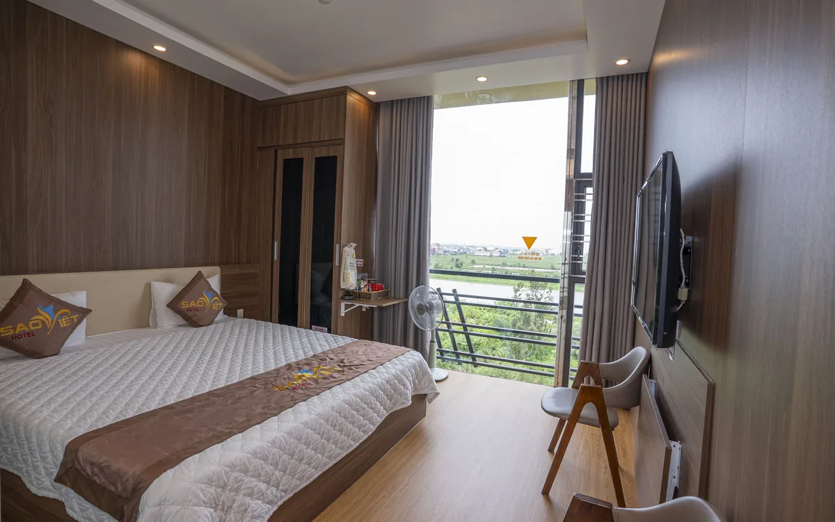 Phòng ốp gỗ có ban công kính tại Sao Việt Hotel nhìn ra khoảng xanh thoáng