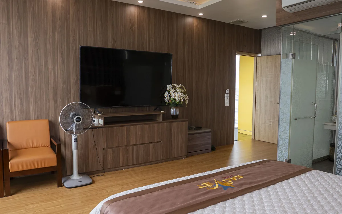 PhÃ²ng Queen lÃ  gÃ¬ â€“ phÃ²ng ná»™i tháº¥t gá»— vá»›i TV lá»›n trÃªn ká»‡ gá»—, gháº¿ bÃ nh vÃ  gÃ³c giÆ°á»ng ga tráº¯ng táº¡i Sao Viá»‡t Hotel