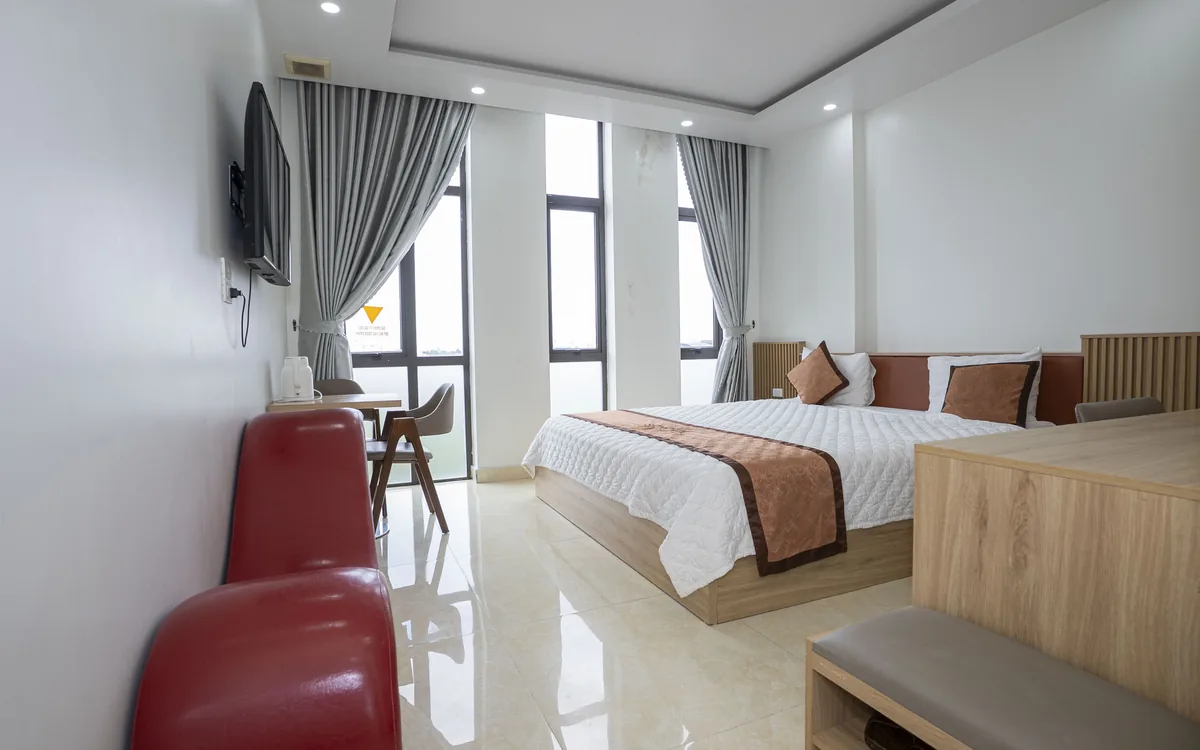 Phòng giường đôi sàn gạch sáng tại Sao Việt Hotel với dãy cửa sổ kính nhìn ra cánh đồng