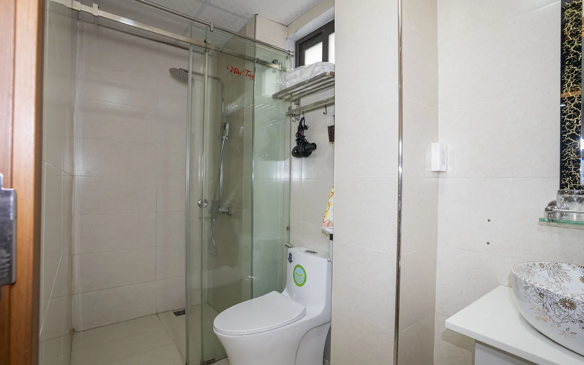 Phòng tắm vách kính với vòi sen, bồn cầu và lavabo tại Sao Việt Hotel