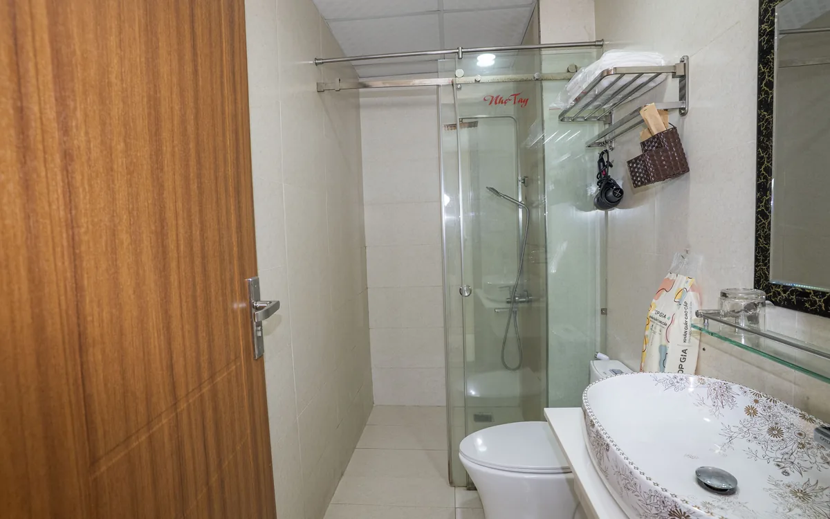 Phòng tắm riêng có vòi sen vách kính, lavabo và gương tại Sao Việt Hotel An Lão