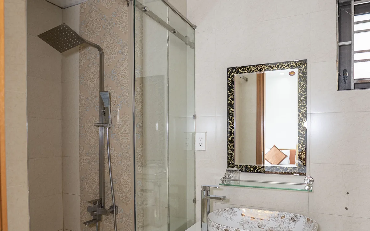 Phòng tắm có vòi sen vách kính, gương khung hoa văn và lavabo đá tại Sao Việt Hotel