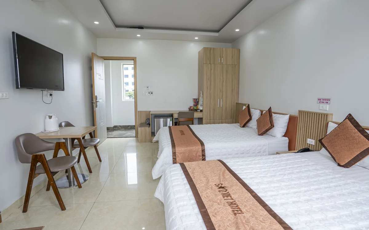 Phòng Triple là gì – phòng hai giưá»ng ga trắng, TV treo tưá»ng, bà n ghế gá»— và tá»§ gá»— tại Sao Việt Hotel