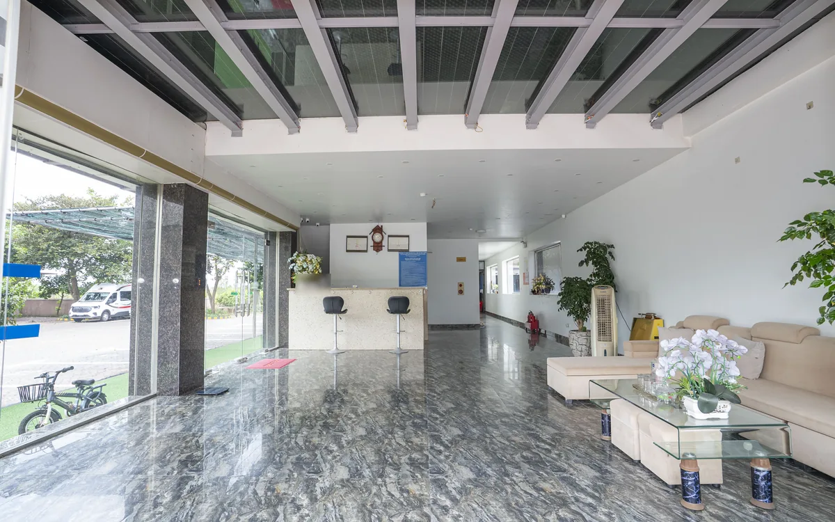 Sảnh tầng trệt Sao Việt Hotel với quầy lễ tân ốp đá, hai ghế bar và sàn đá bóng